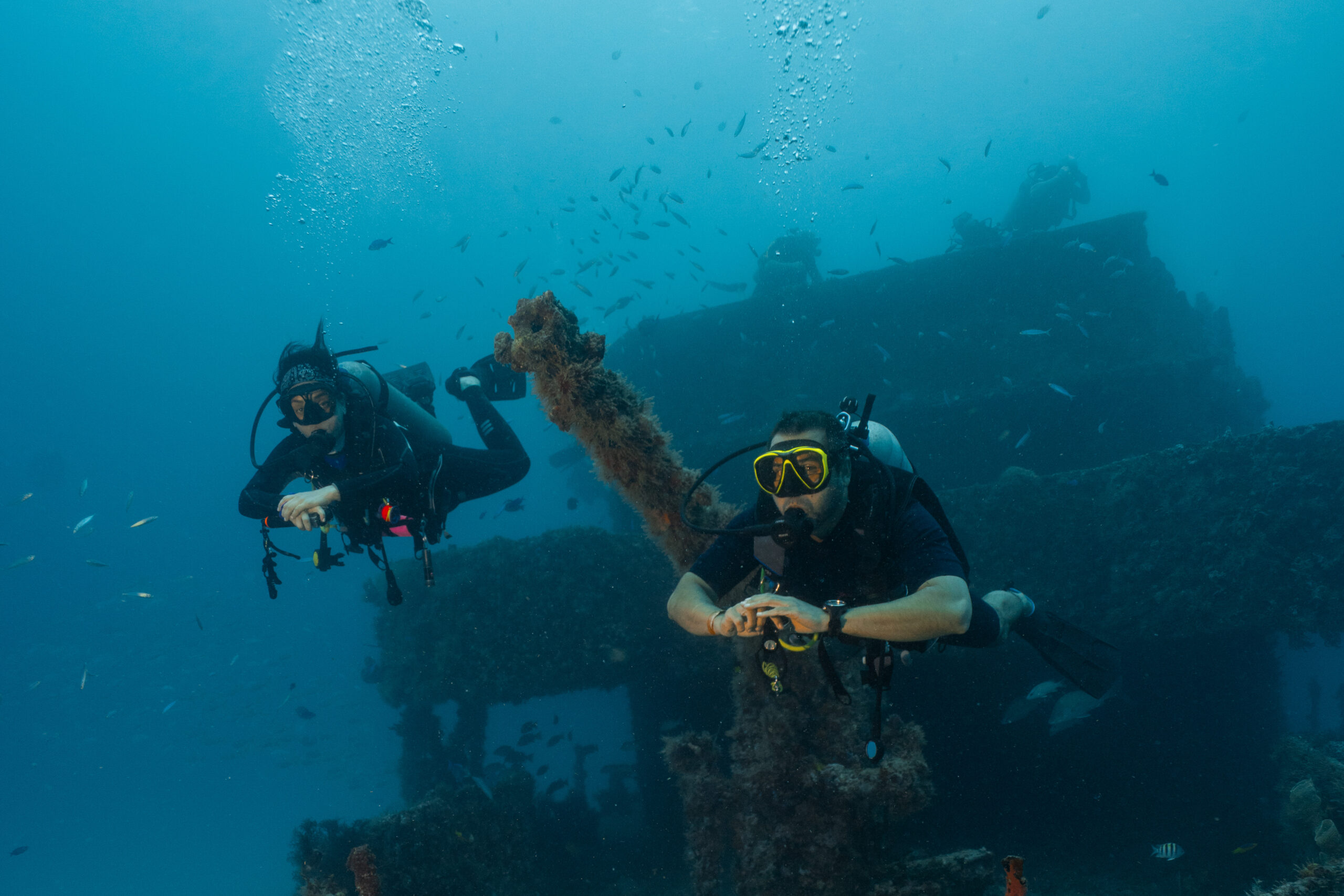 couple of divers posing in front of a sunken ship, technical diving