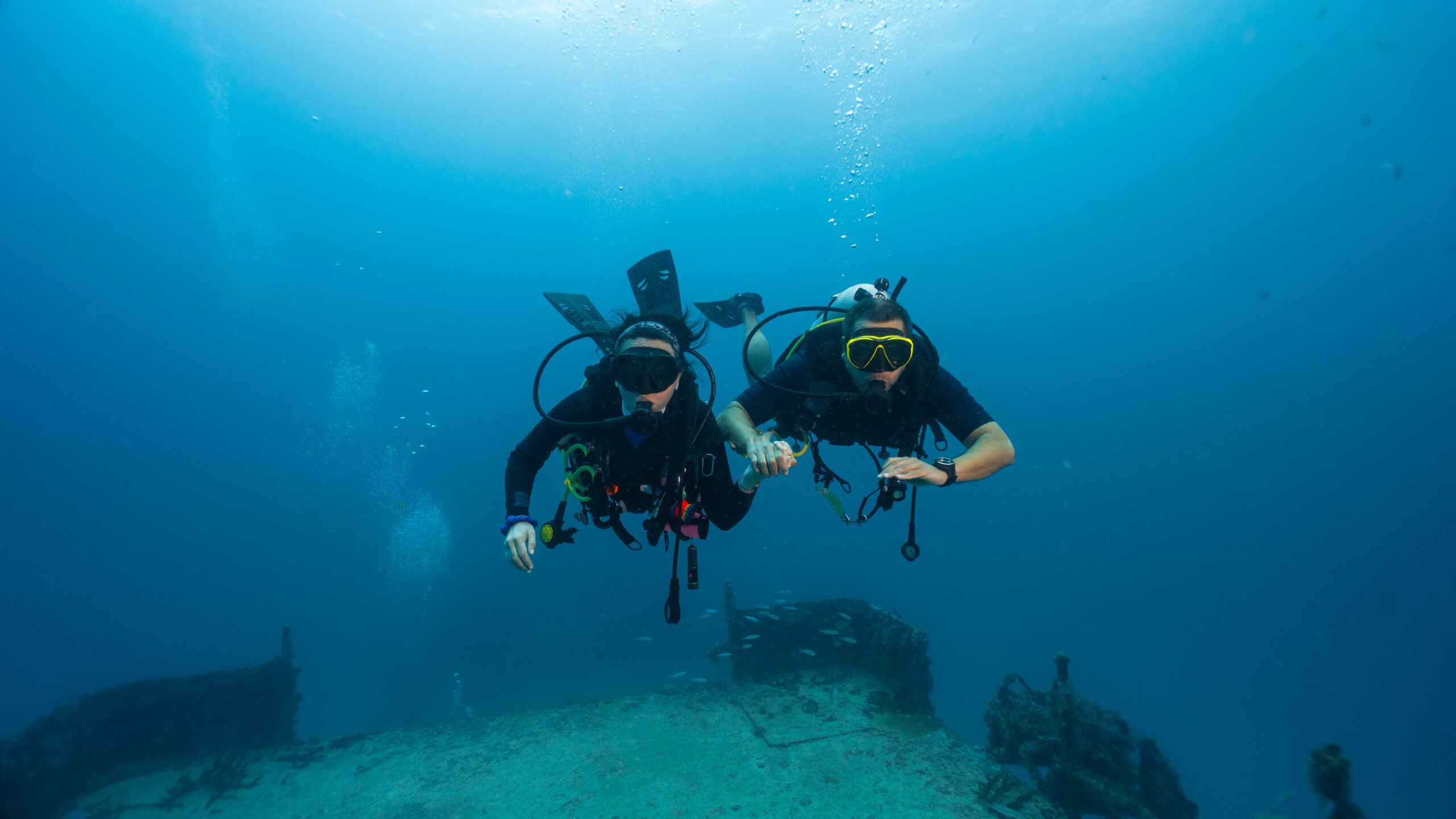 couple of divers posing in front of a sunken ship, technical diving